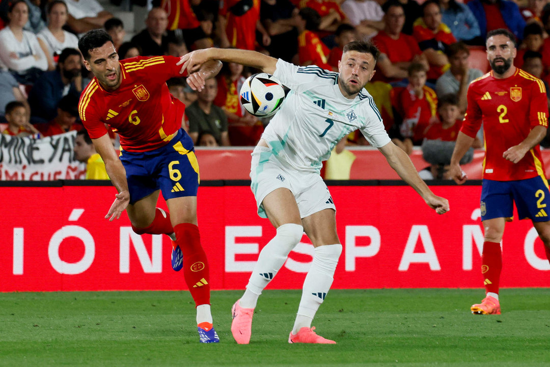 El centrocampista de la selección española Mikel Merino (i) pelea un balón con Conor McMenamin, de Irlanda del Norte, durante el partido amistoso de fútbol disputado en el estadio de Son Moix. EFE/Cati Cladera