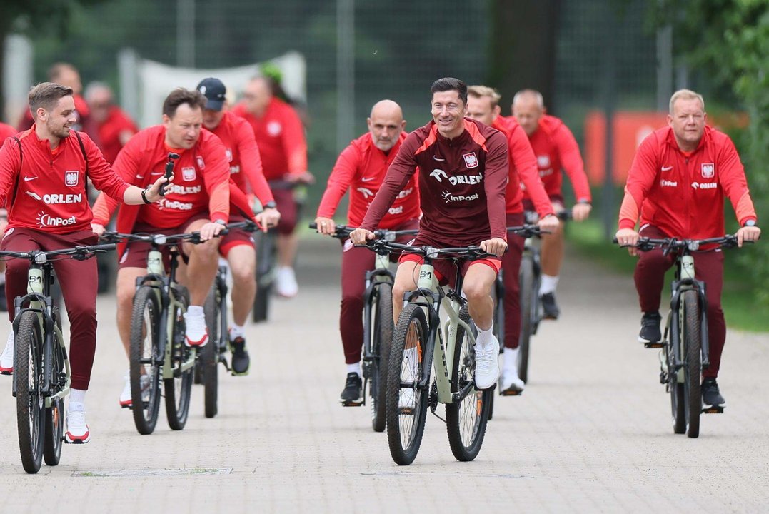 Robert Lewandowski (C) y sus compañeros llegan en bici a un entrenamiento.EFE/EPA/Leszek Szymanski