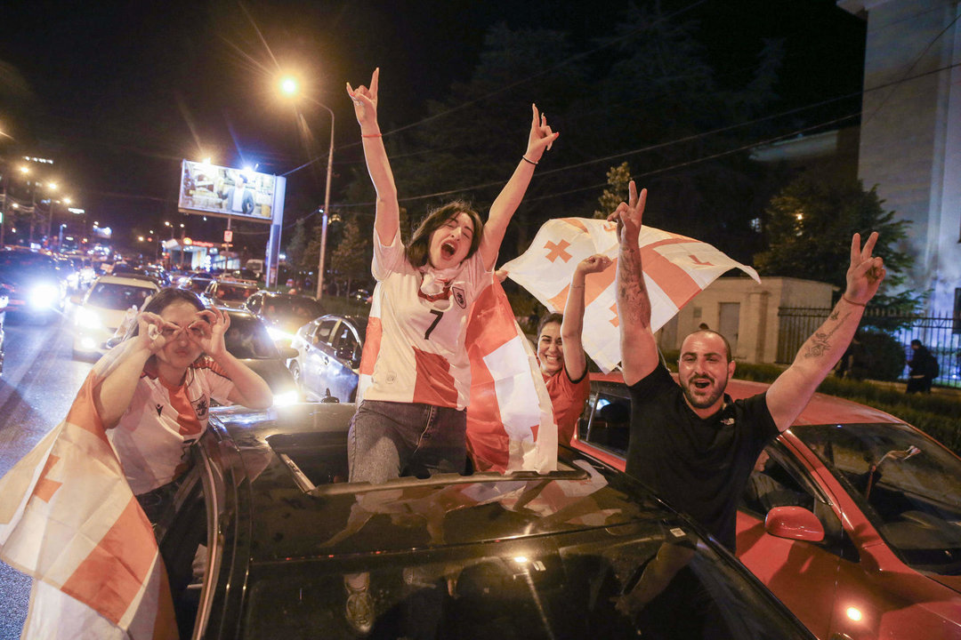 Decenas de miles de aficionados se volcaron anche a la calles de Tiflis y otras ciudades de Georgia para celebrar hasta altas de la madrugada la victoria (2-0) de la selección nacional sobre Portugal que le dio el pase a octavos de final del Eurocopa, donde le espera España.En medio del estruendo de los fuegos artificiales y de los cláxones de los automóviles engalanados con la rojiblanca bandera del país se oían los gritos de júbilo de los aficionados por el histórico logro del fútbol georgiano en su primera participación en un torneo continental.  EFE/ Misha Vignanski.